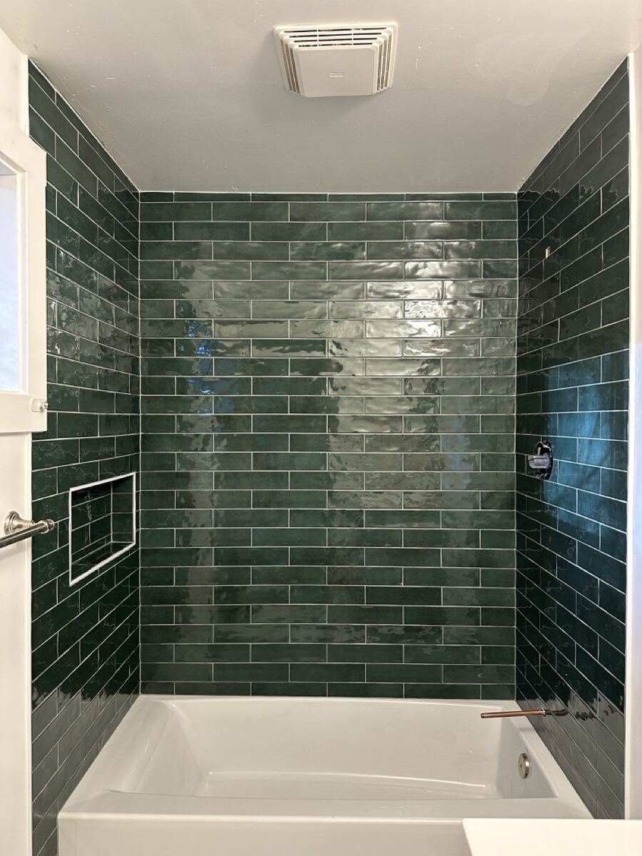 Green subway tile tub surround with a niche