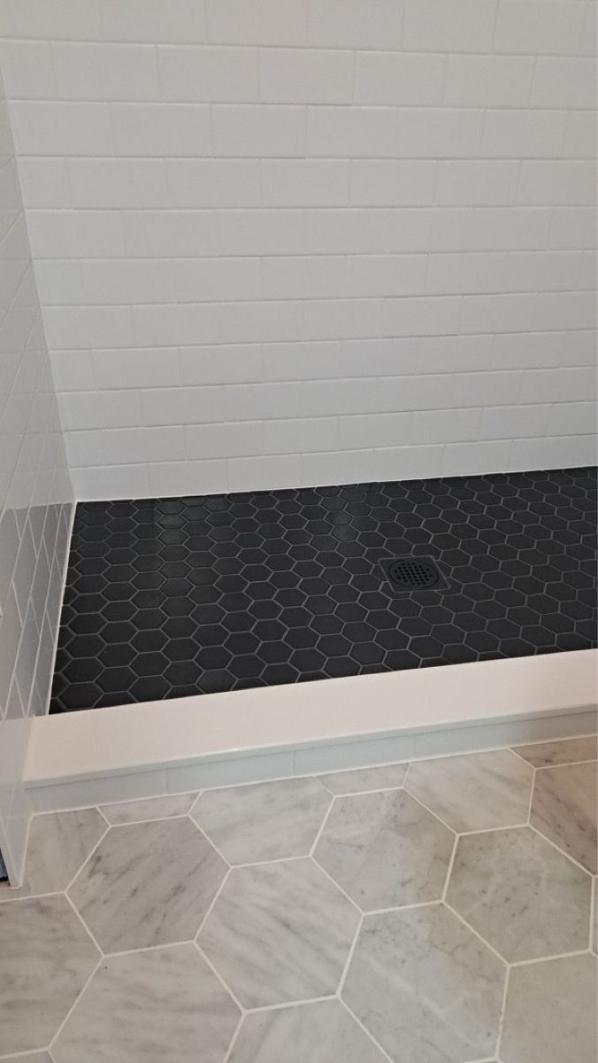 Black mosaic shower floor and hexagon floor tile