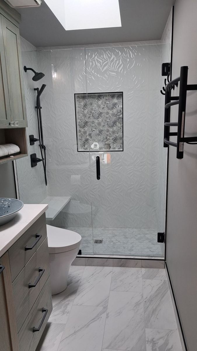 Bathroom with skylight, glass shower and patterned tile