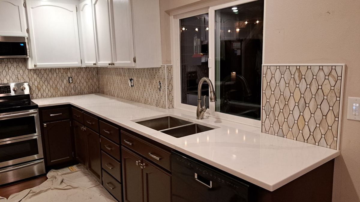 Dark lower cabinets with white quartz and a patterned backsplash