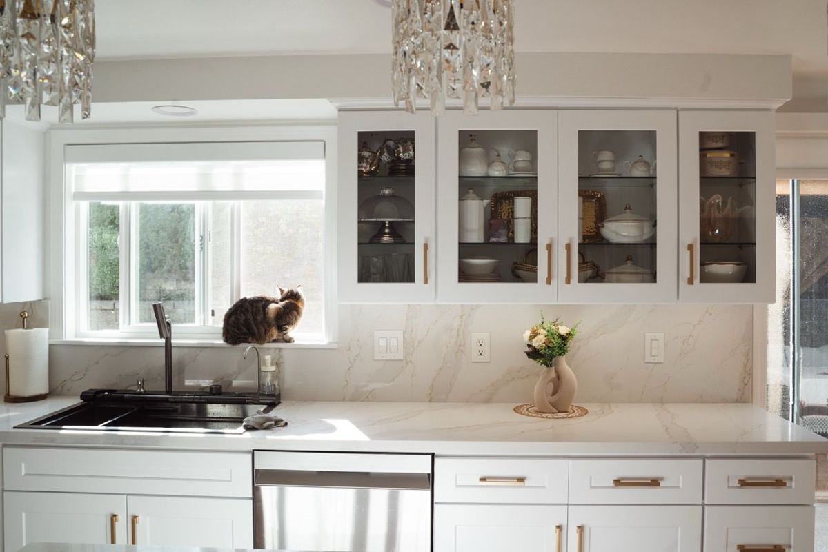 White kitchen with glass-front cabinets and quartz counters