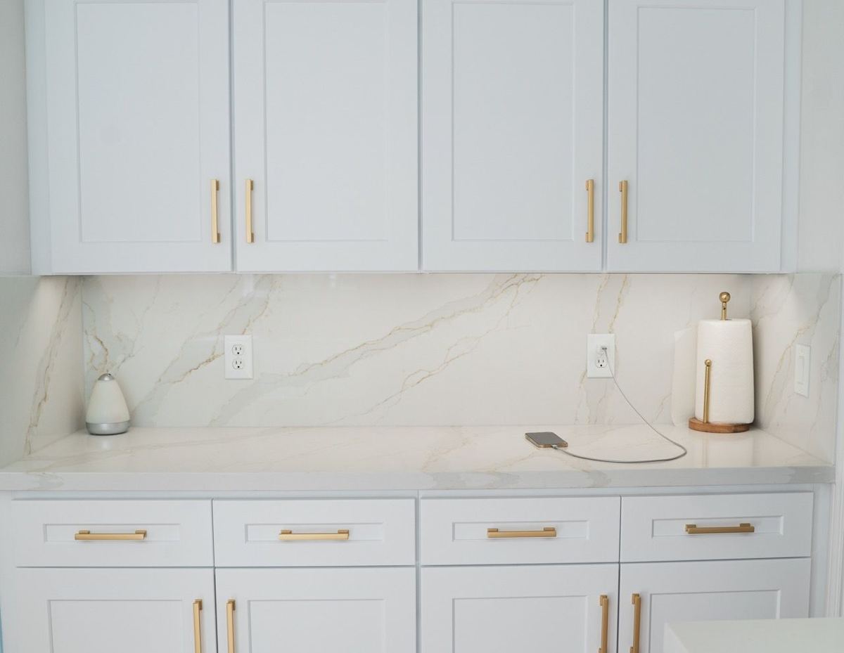 Marble-look slab backsplash with white cabinets